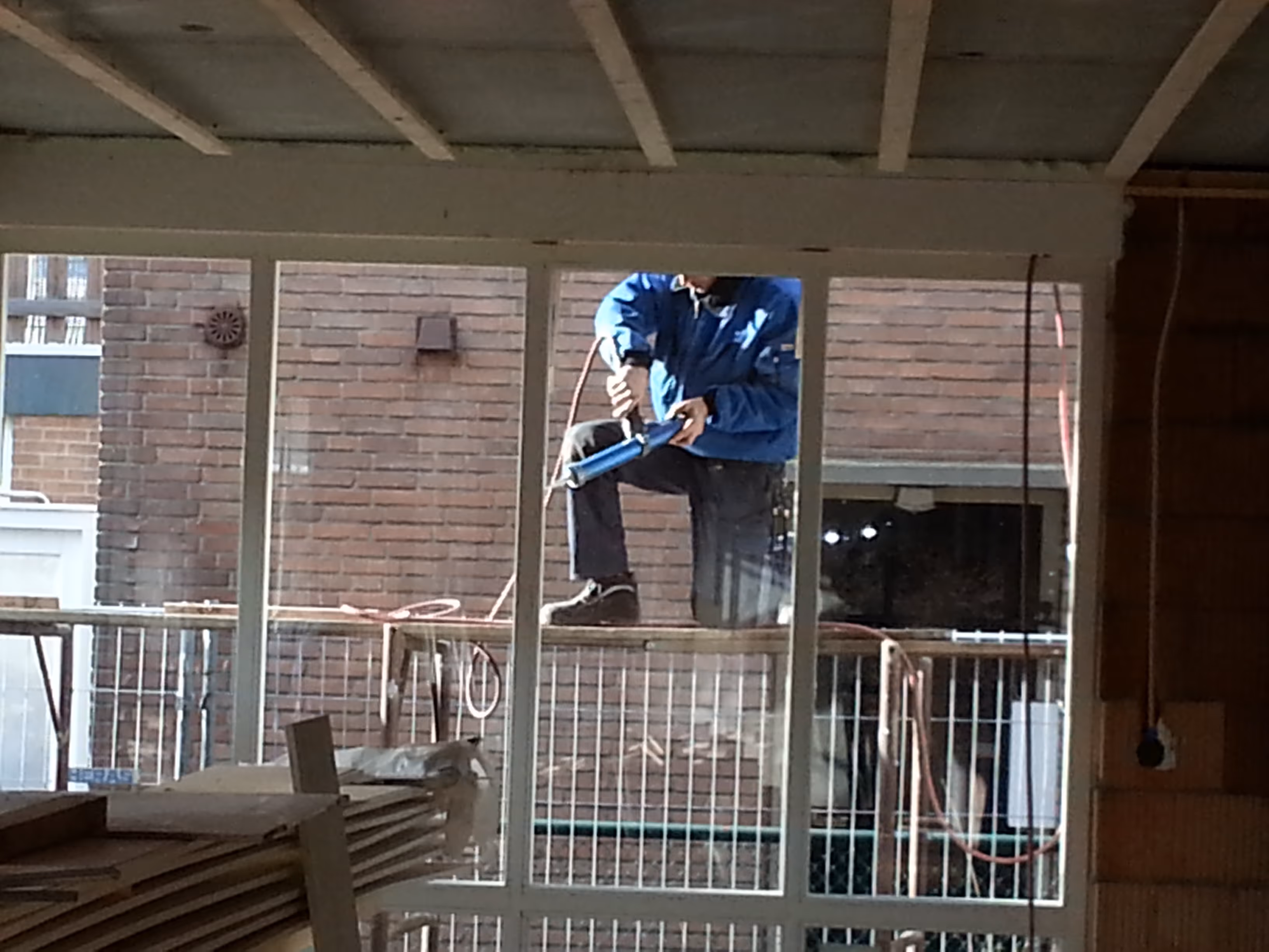Glaszetter van Glashandel Groenewegen aan het werk op een balkon