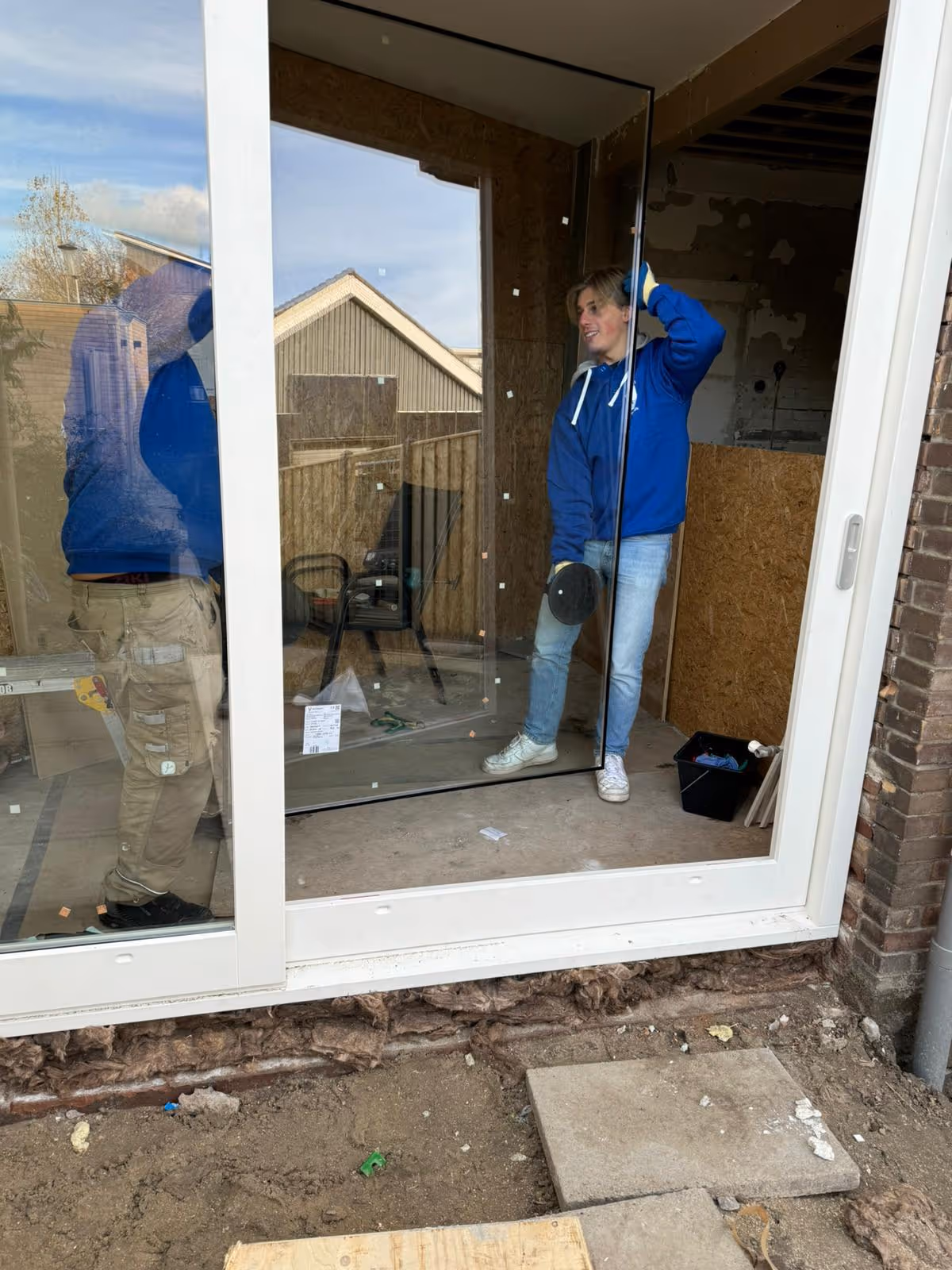 Glaszetter van Glashandel Groenewegen plaatst een glazen schuifdeur