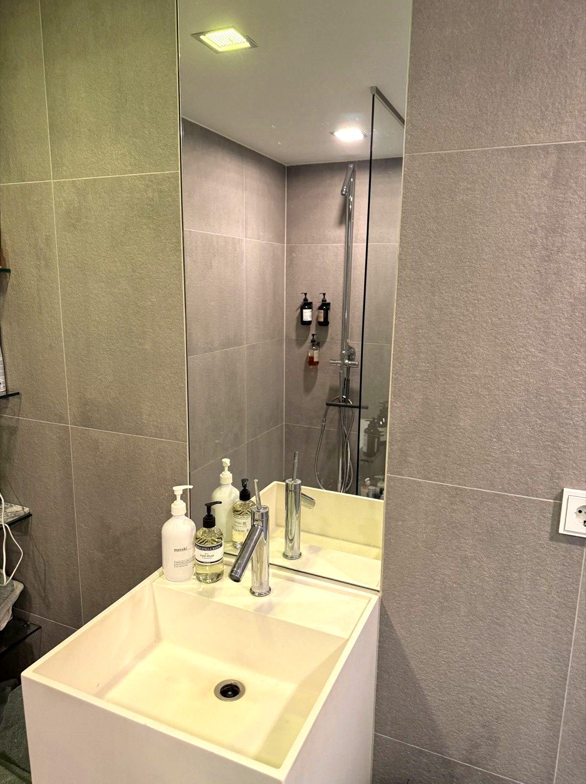 Gerenoveerde badkamer in Naaldwijk met glazen douchewand en badombouw