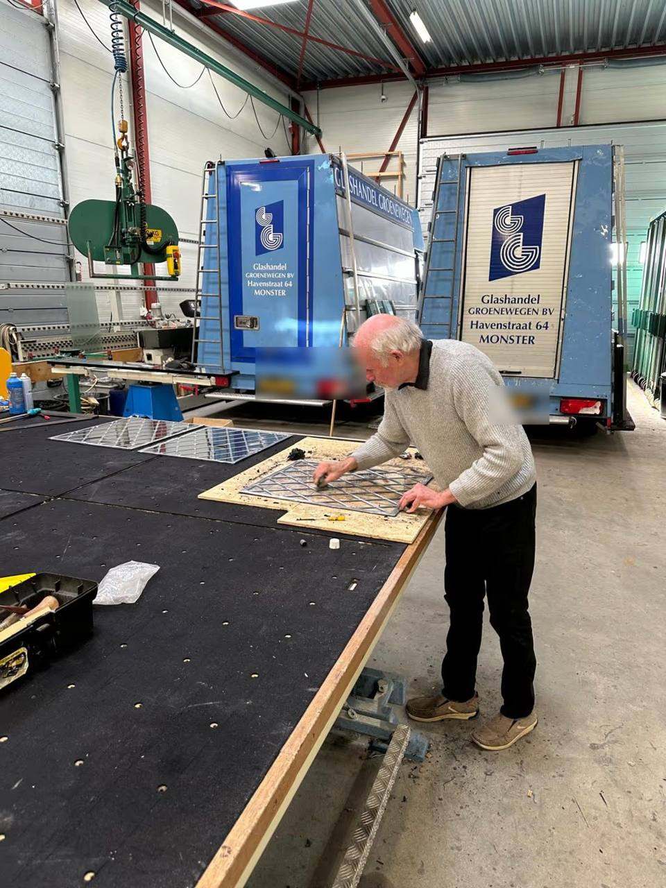 Glaszetter van Glashandel Groenewegen maakt glas-in-lood aan de werktafel